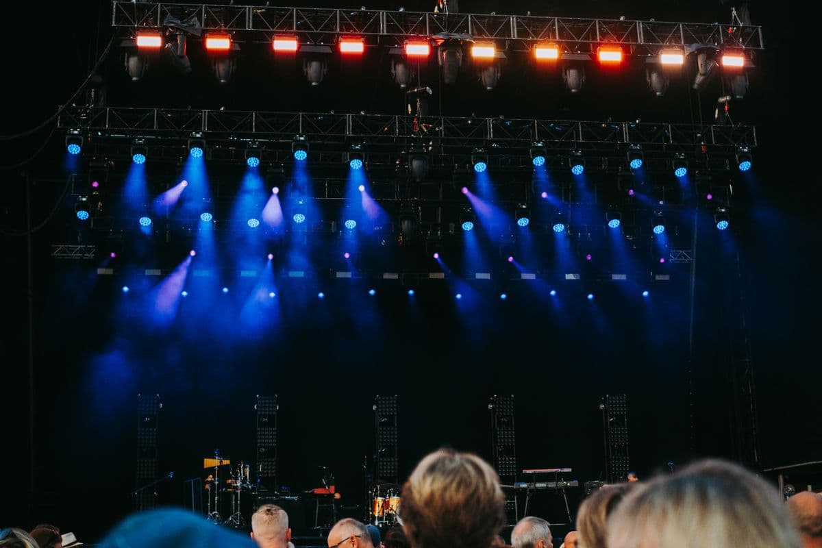 A crowd under concert stage lights